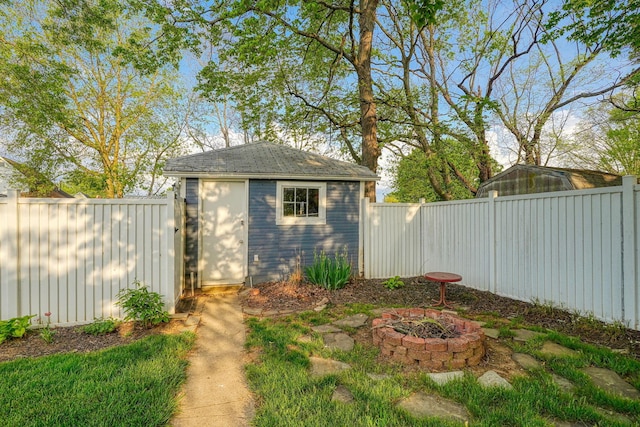 view of shed featuring a fire pit and a fenced backyard