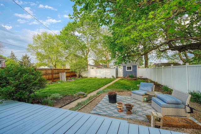 wooden deck with a fenced backyard, an outdoor structure, a yard, and a storage shed