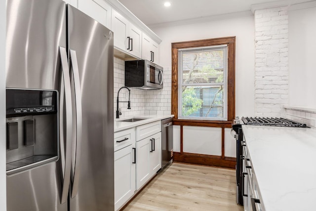 1065-1067 Franklin Ave, Columbus, OH 43205 - kitchen with appliances with stainless steel finishes, a sink, light wood finished floors, tasteful backsplash, and ornamental molding
