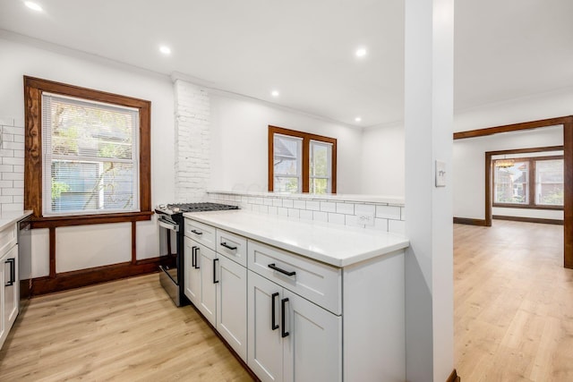 1065-1067 Franklin Ave, Columbus, OH 43205 - kitchen with stainless steel range with gas cooktop, light wood-style floors, ornamental molding, backsplash, and plenty of natural light