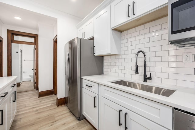 1065-1067 Franklin Ave, Columbus, OH 43205 - kitchen with stainless steel appliances, a sink, ornamental molding, decorative backsplash, and white cabinets