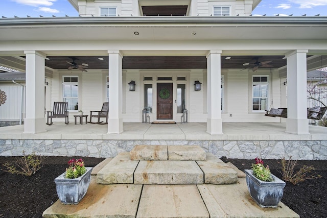 doorway to property featuring covered porch and ceiling fan