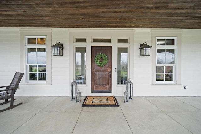 view of exterior entry featuring covered porch