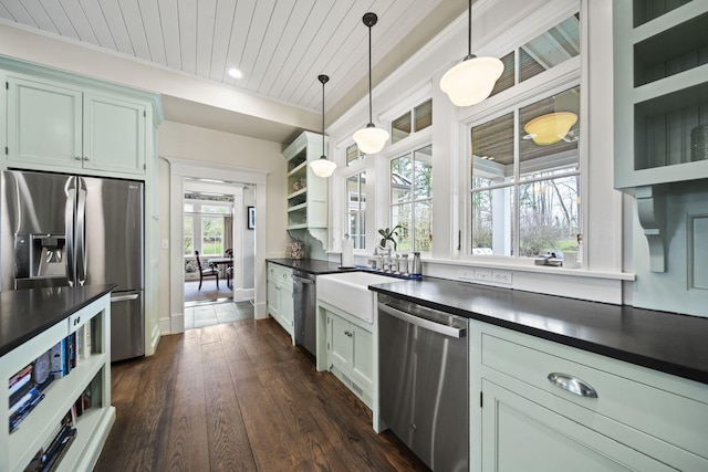 kitchen featuring baseboards, open shelves, decorative light fixtures, dark countertops, and stainless steel appliances