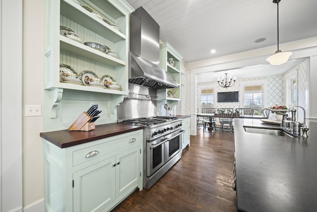 kitchen featuring open shelves, wall chimney exhaust hood, a sink, wood counters, and range with two ovens
