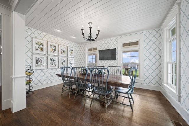 dining space featuring wallpapered walls, an inviting chandelier, baseboards, and wood finished floors