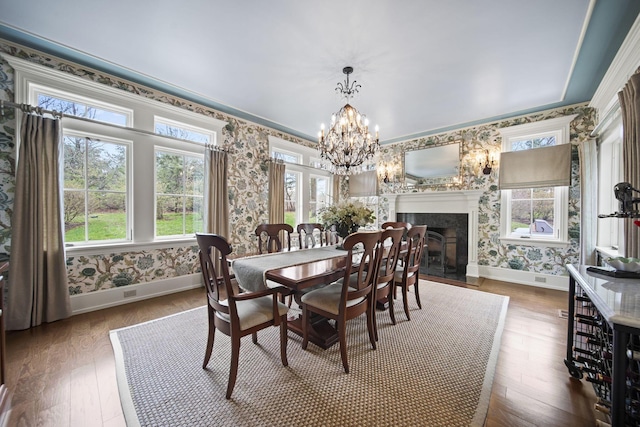 dining room featuring wallpapered walls, an inviting chandelier, and baseboards