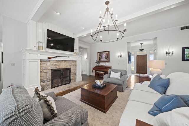 living area featuring visible vents, a stone fireplace, crown molding, and wood finished floors