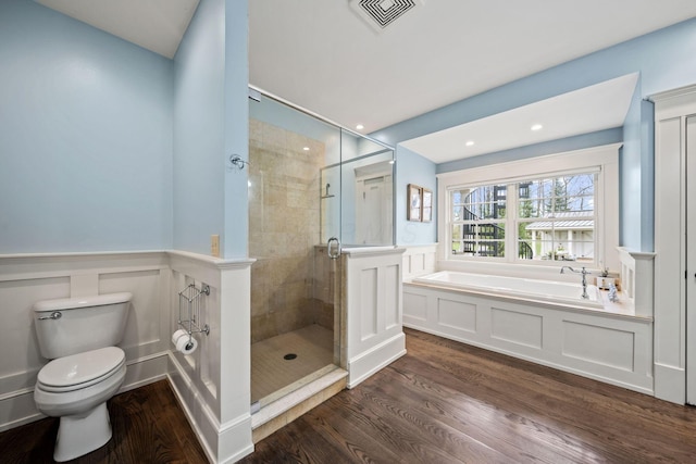 bathroom featuring visible vents, toilet, a shower stall, wood finished floors, and a garden tub
