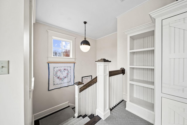 stairway featuring crown molding, baseboards, and carpet