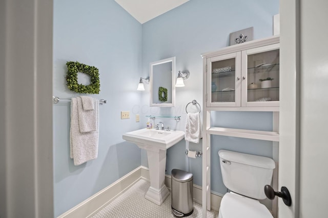 bathroom with tile patterned floors, baseboards, and toilet