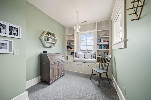 living area featuring visible vents, baseboards, built in shelves, a chandelier, and carpet floors