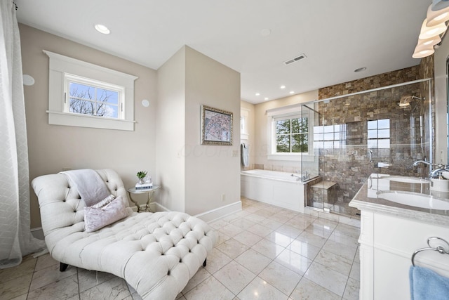 bathroom featuring a sink, double vanity, a stall shower, visible vents, and a garden tub