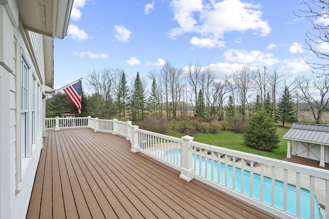 wooden terrace featuring an outdoor pool, an outdoor structure, and a lawn