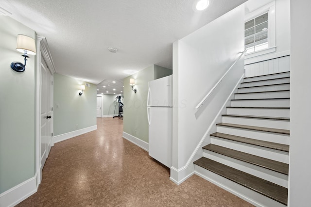 stairs featuring baseboards, recessed lighting, and a textured ceiling