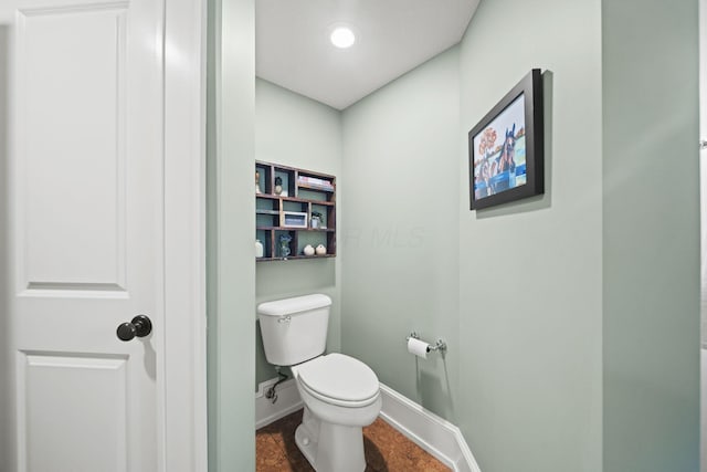 bathroom featuring toilet and baseboards