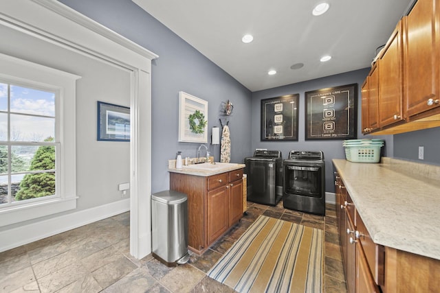 bar featuring a sink, baseboards, separate washer and dryer, and a wealth of natural light