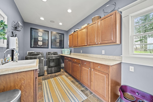 clothes washing area featuring baseboards, a sink, recessed lighting, cabinet space, and washing machine and clothes dryer
