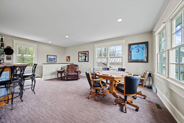 carpeted home office featuring visible vents, baseboards, recessed lighting, and a healthy amount of sunlight