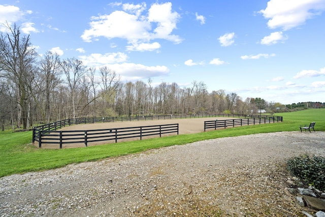 exterior space with an enclosed area, a rural view, and a lawn