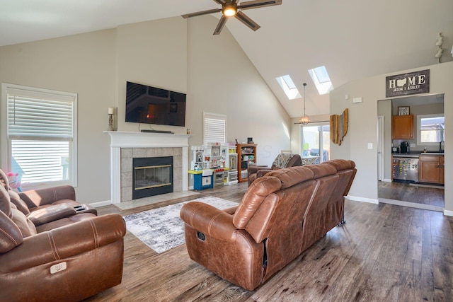 2655 Cross Creek Ave, Lancaster, OH 43130 - living room featuring a skylight, baseboards, high vaulted ceiling, a ceiling fan, and dark wood-type flooring
