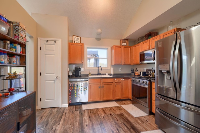 2655 Cross Creek Ave, Lancaster, OH 43130 - kitchen with a sink, dark countertops, stainless steel appliances, vaulted ceiling, and wood finished floors