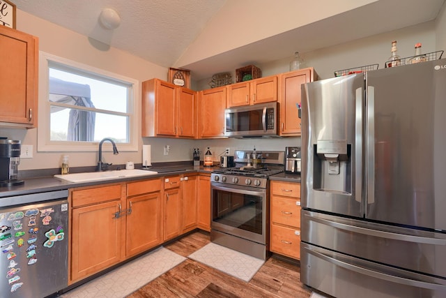 2655 Cross Creek Ave, Lancaster, OH 43130 - kitchen featuring lofted ceiling, a sink, light wood-style floors, stainless steel appliances, and dark countertops