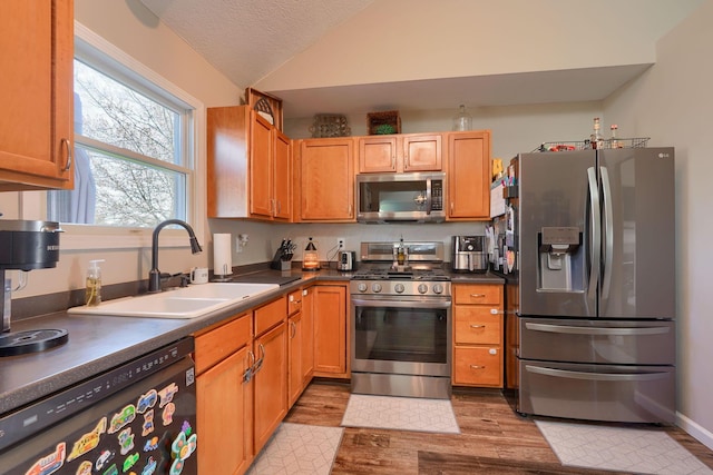 2655 Cross Creek Ave, Lancaster, OH 43130 - kitchen featuring light wood-style flooring, a sink, appliances with stainless steel finishes, dark countertops, and vaulted ceiling