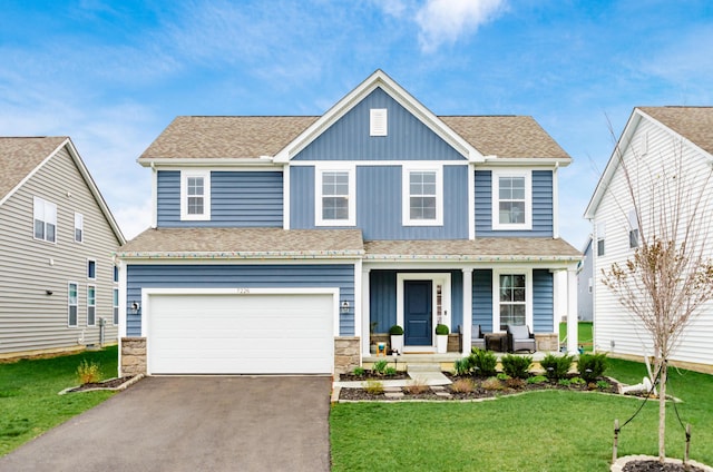 view of front of property featuring a garage, driveway, a porch, and a front lawn
