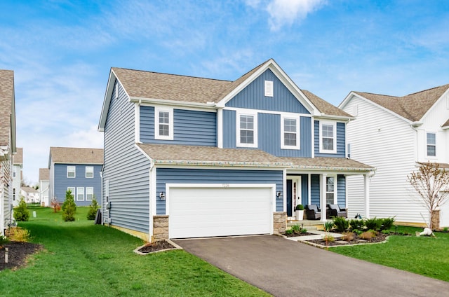 view of front facade featuring an attached garage, driveway, a front lawn, and covered porch