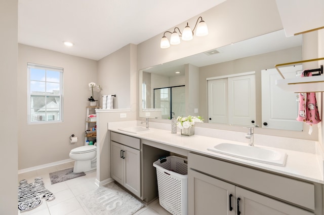 full bath featuring double vanity, baseboards, a stall shower, and a sink