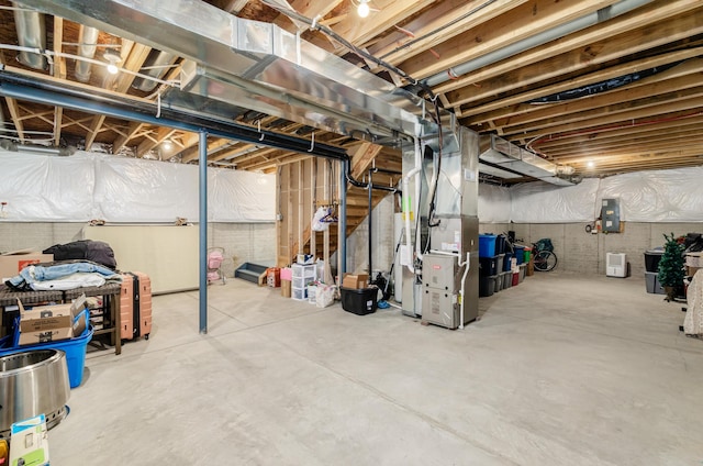 unfinished basement featuring electric panel and heating unit