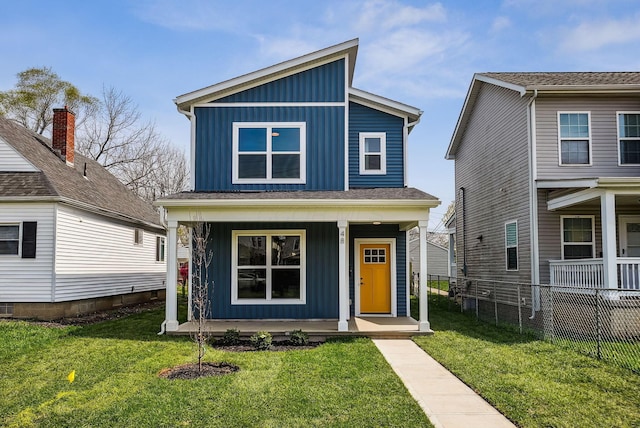 view of front of home with a front yard, board and batten siding, fence, and covered porch