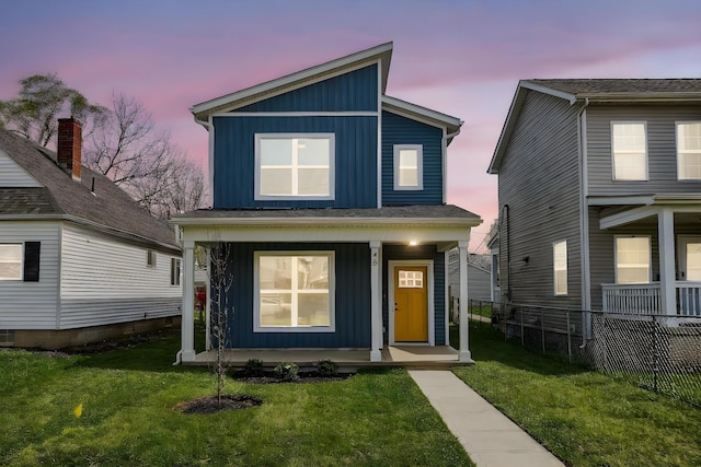 view of front of property featuring a front yard, a porch, board and batten siding, and fence