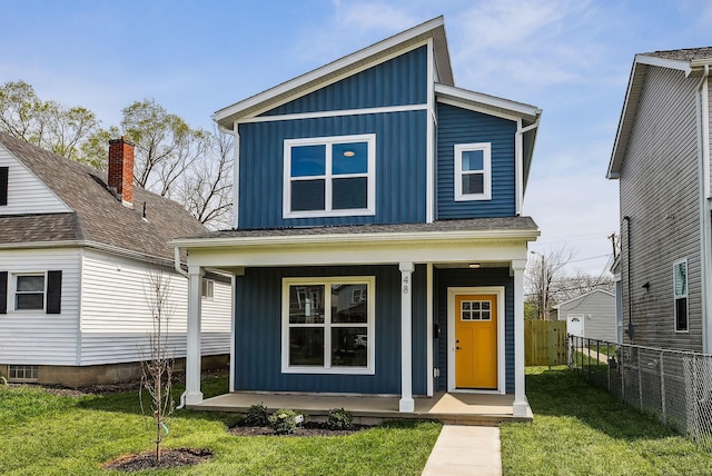 view of front of home featuring a porch, board and batten siding, fence, and a front lawn
