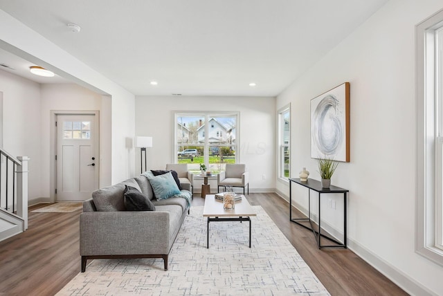 living room featuring recessed lighting, stairs, baseboards, and wood finished floors