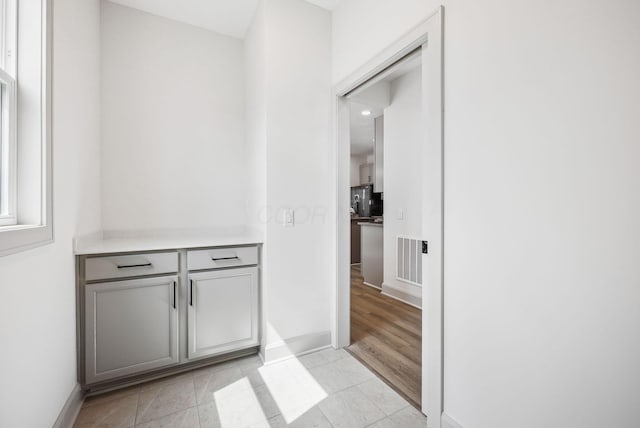 interior space with light tile patterned floors, baseboards, and visible vents