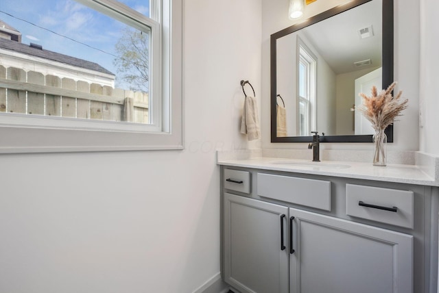 bathroom with vanity, visible vents, and a healthy amount of sunlight