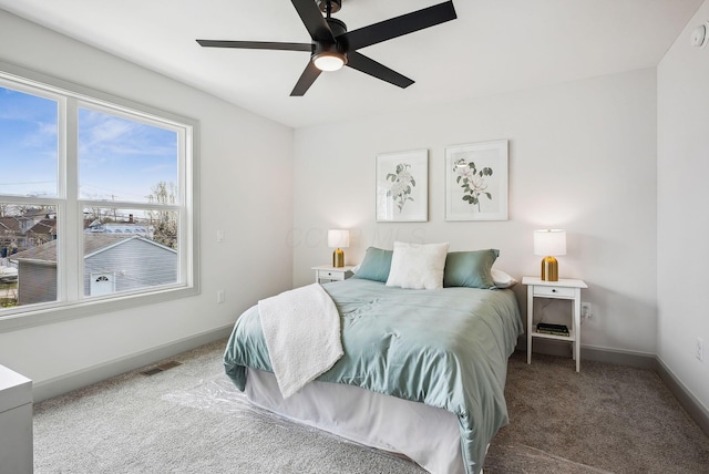 carpeted bedroom with visible vents, baseboards, and ceiling fan