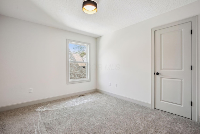 unfurnished room featuring baseboards and carpet