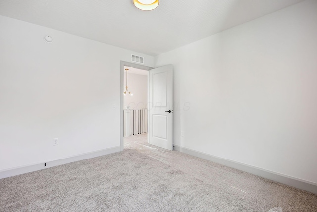unfurnished room featuring visible vents, baseboards, and light carpet