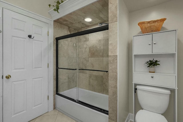bathroom with shower / bath combination with glass door, tile patterned flooring, and toilet