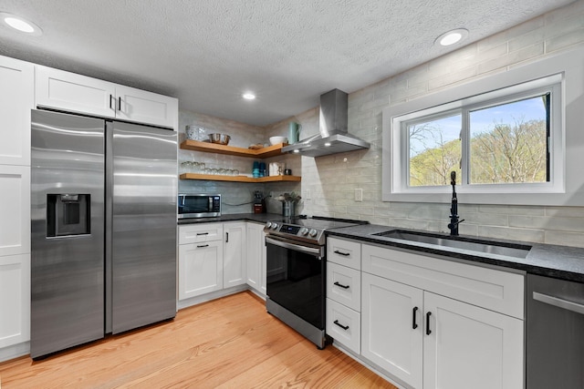 19990 Sowers Rd, Laurelville, OH 43135 - kitchen with light wood finished floors, a sink, wall chimney exhaust hood, backsplash, and appliances with stainless steel finishes