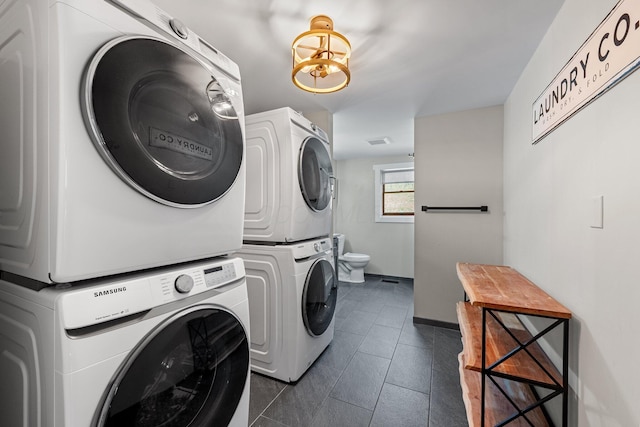 19990 Sowers Rd, Laurelville, OH 43135 - clothes washing area featuring visible vents, stacked washer / dryer, dark tile patterned floors, and baseboards