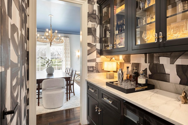 2 Albery Loop, New Albany, OH 43054 - bar featuring dark wood-type flooring, an inviting chandelier, and hanging light fixtures