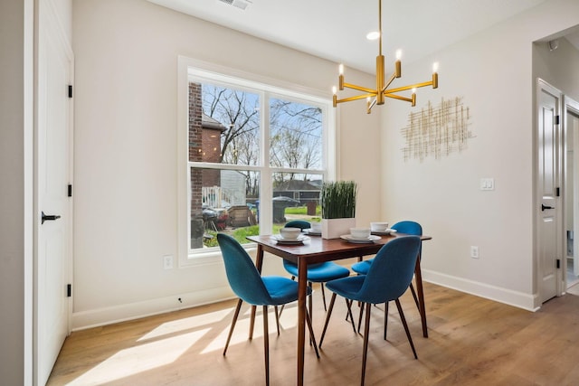 dining room with recessed lighting, light wood finished floors, baseboards, and a notable chandelier