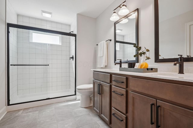 full bath featuring a sink, a shower stall, double vanity, and toilet
