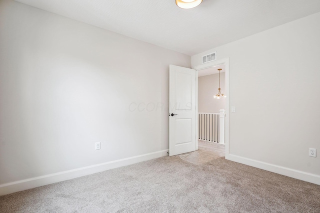 unfurnished room featuring baseboards, visible vents, and light colored carpet