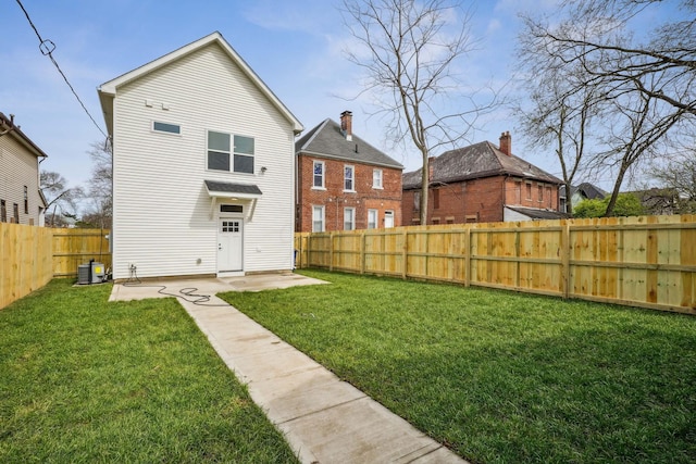 rear view of house with a lawn, a fenced backyard, and a patio area