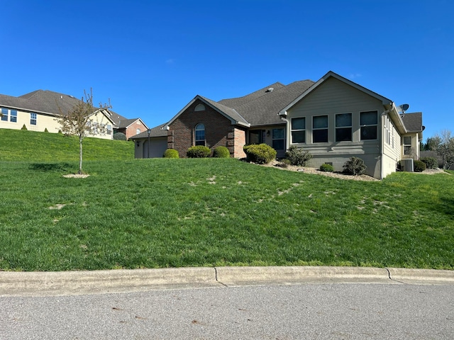 ranch-style house with a front yard, central AC unit, and a shingled roof